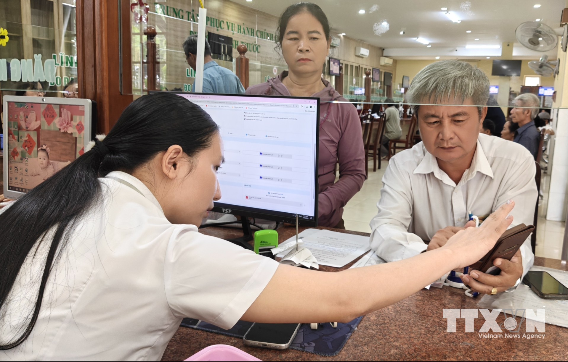 Trung tâm Phục vụ hành chính công phường Bình Phước tận tình hướng dẫn người dân đến thực hiện thủ tục hành chính. (Ảnh: K GỬIH/TTXVN)